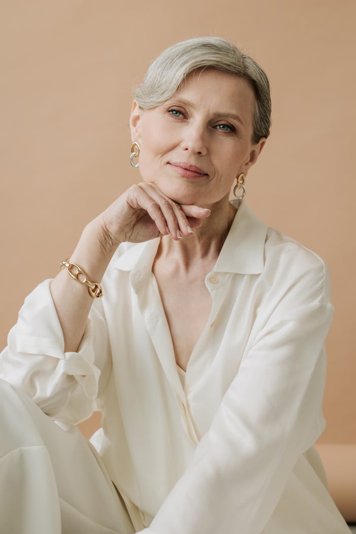 Elegant Old Woman in White Outfit and Gold Accessories